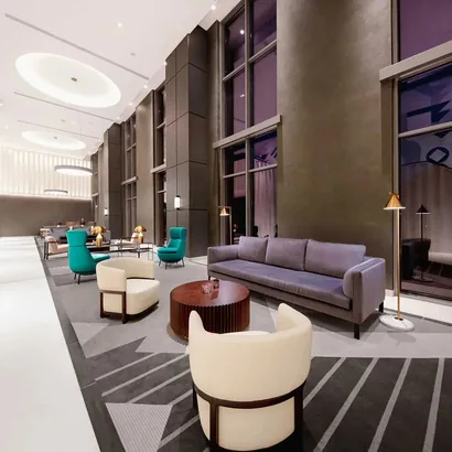 Contemporary hotel lobby lounge with teal and cream armchairs
