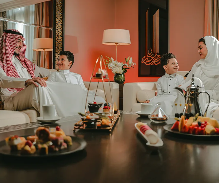 Saudi family enjoying afternoon tea in a hotel suite
