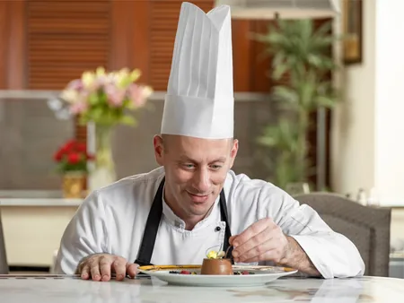 Pastry chef plating a chocolate dessert